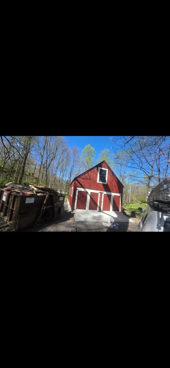 Freshly repainted red barn with clean white trim and doors after exterior work