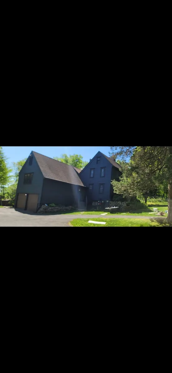 Side view of the same home with a fresh dark blue exterior finish