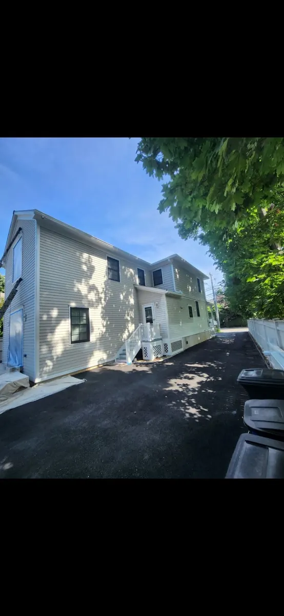 White-sided home exterior during preparation and repainting